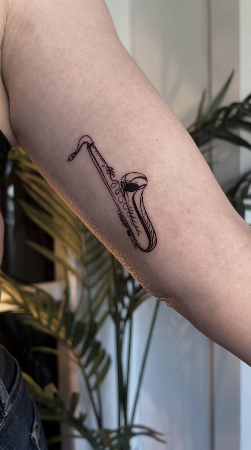 Fine line tatuering Uppsala — saxofon, underarm
