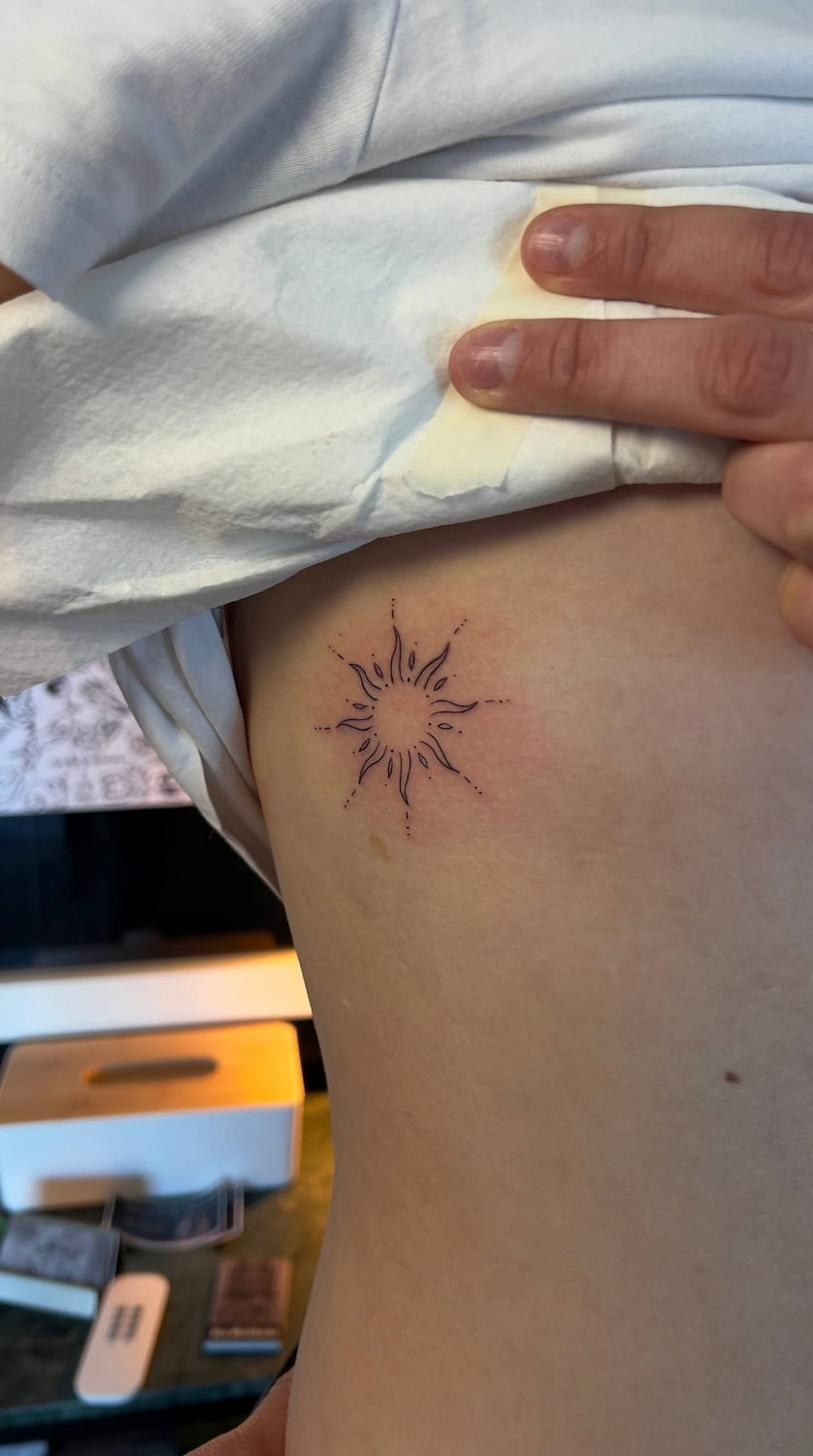 Fine line tatuering nära Stockholm — sol-motiv på revben