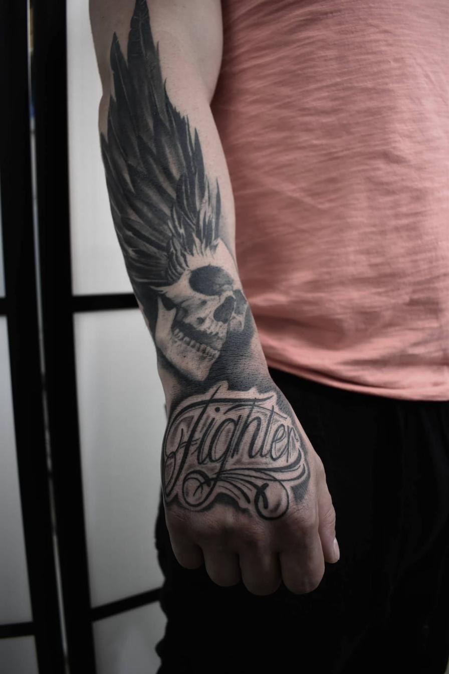 Chicano tatuering Uppsala — skalle med vinge och lettering 'Fighter'